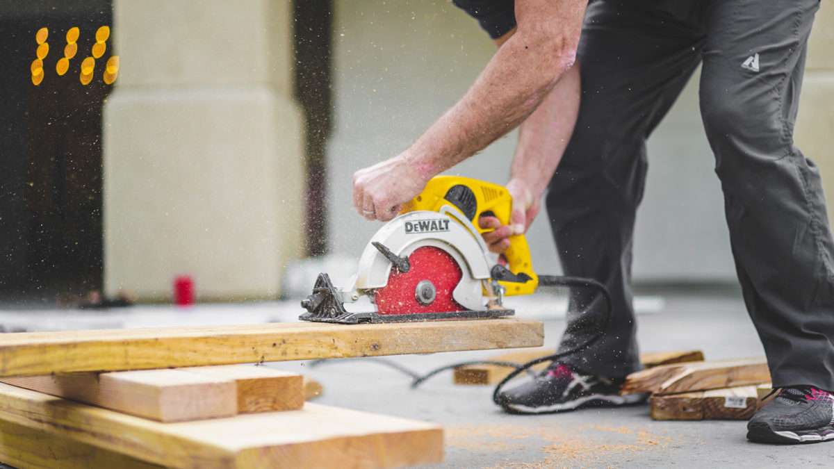 Construction Worker Cutting Wood at True Living